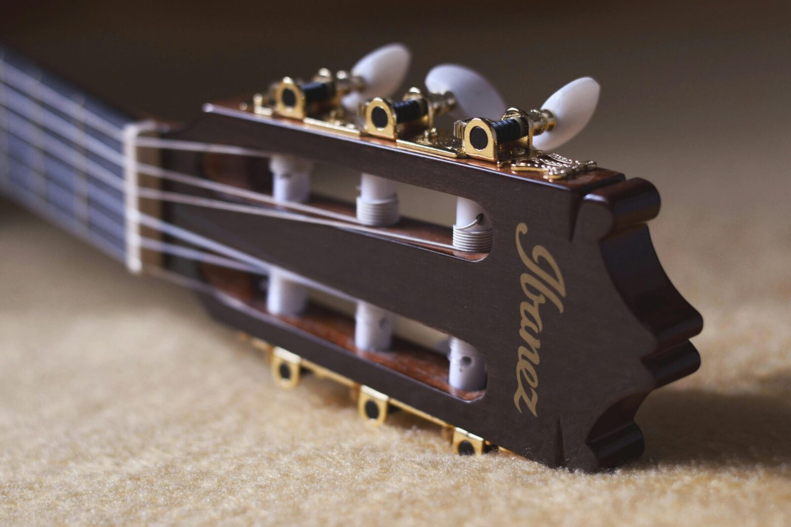 Detailed close-up of an Ibanez classical guitar headstock showcasing craftsmanship.